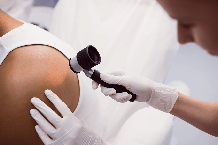 Specialist examines soft tissue mass on the skin of a patient's shoulder